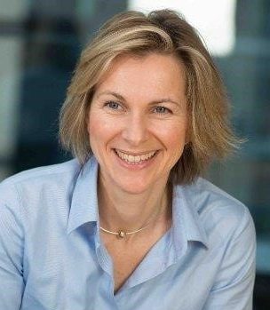 Caroline Colliston smiling broadly in a blue shirt