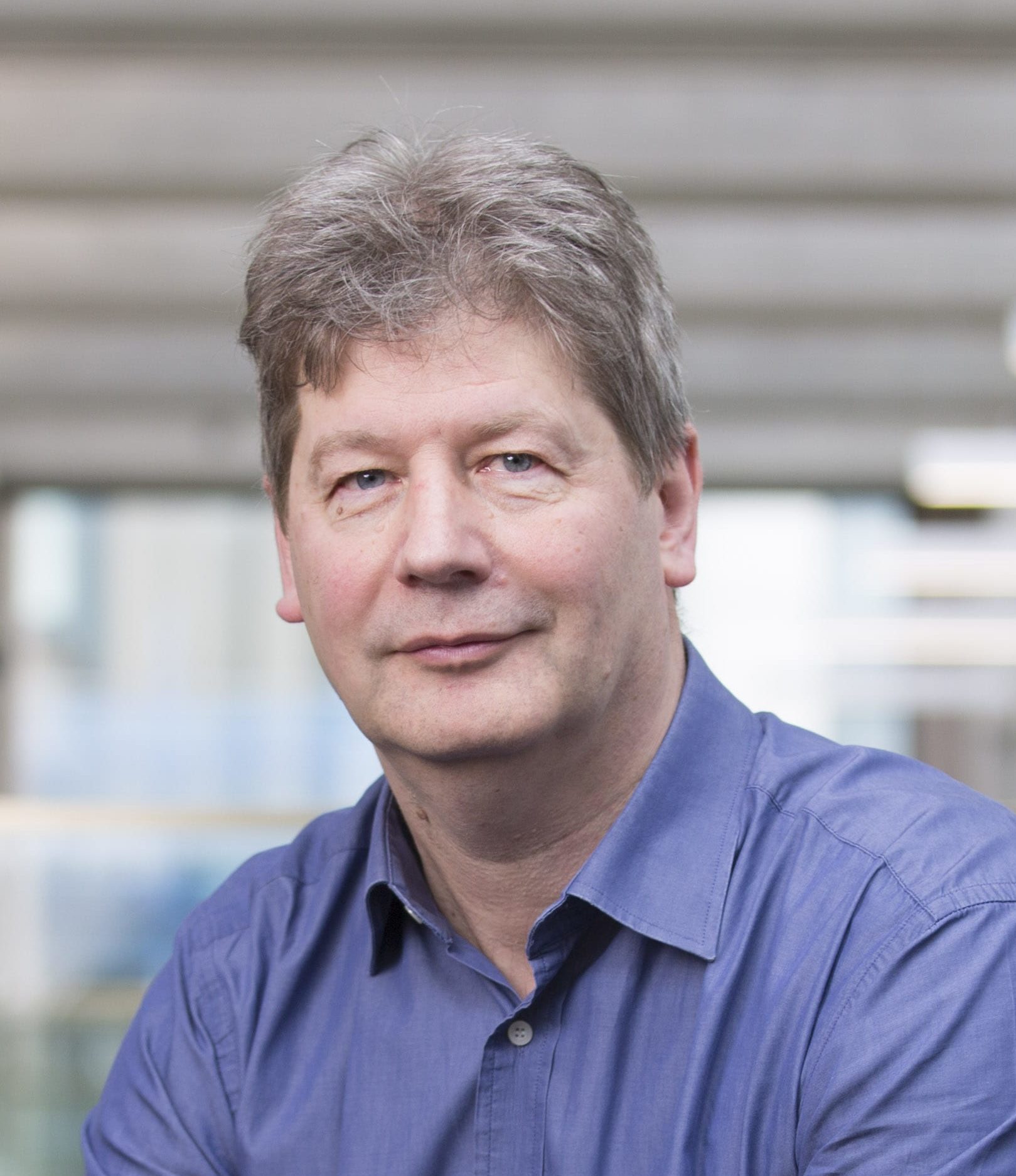 Ian Thomson sits in a light filled atrium