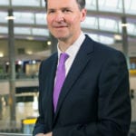 John Holland-Kaye, stands in an airport terminal