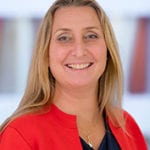 Kirsty Green-Mann smiling, wearing a red jacket