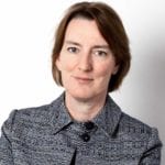 Susannah Clements in a black and white jacket looks at the camera