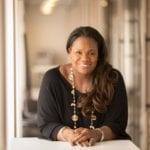 Vivian Hunt smiles and leans on a table