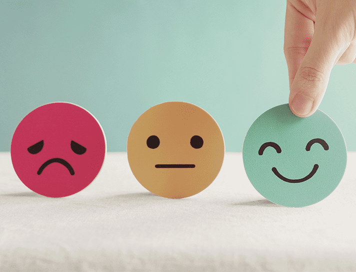 three coloured circles with sad, accepting and smiley faces in black felt tip pen