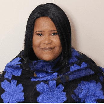 Sandra Kerr wearing a dark blue flowered shawl smiles into the camera