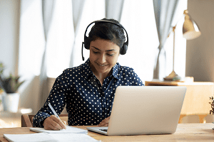 A young woman at a laptop depicting the BITC Job Coaching programme, one of the supporting people initiatives from BITC. 