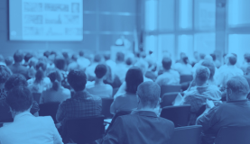 People sitting in an auditorium looking at presentation.