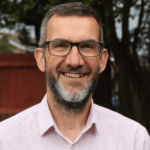 Mike Crowther wearing glasses, smiling at the camera